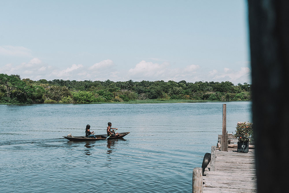Crianças ribeirinhas usando um dos principais meios de transporte na Amazônia.